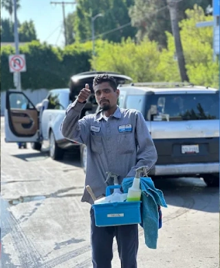 Fashion Square Car Wash team member carrying cleaning supplies between customer vehicles